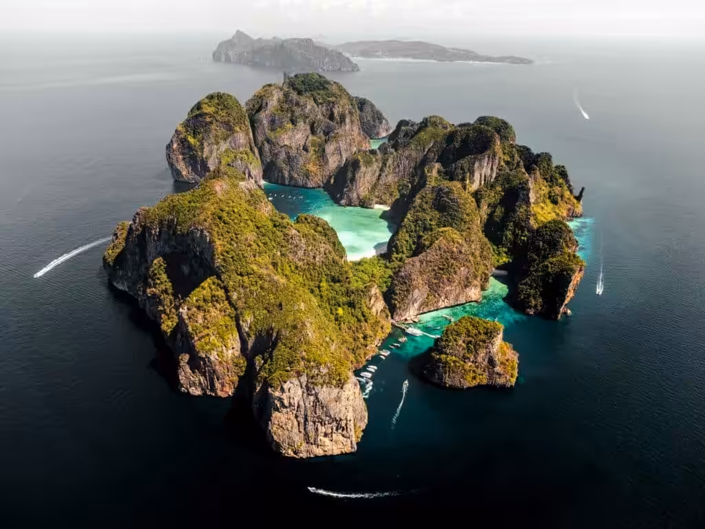 Aerial view of Phi Phi Islands limestone karst formations with emerald lagoons and speedboats